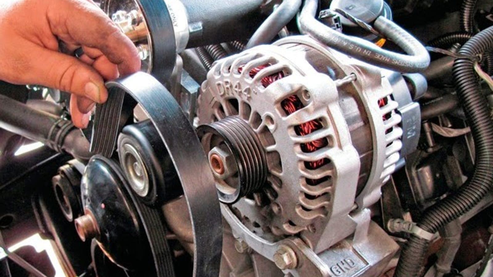 Mechanic testing a car battery under the hood