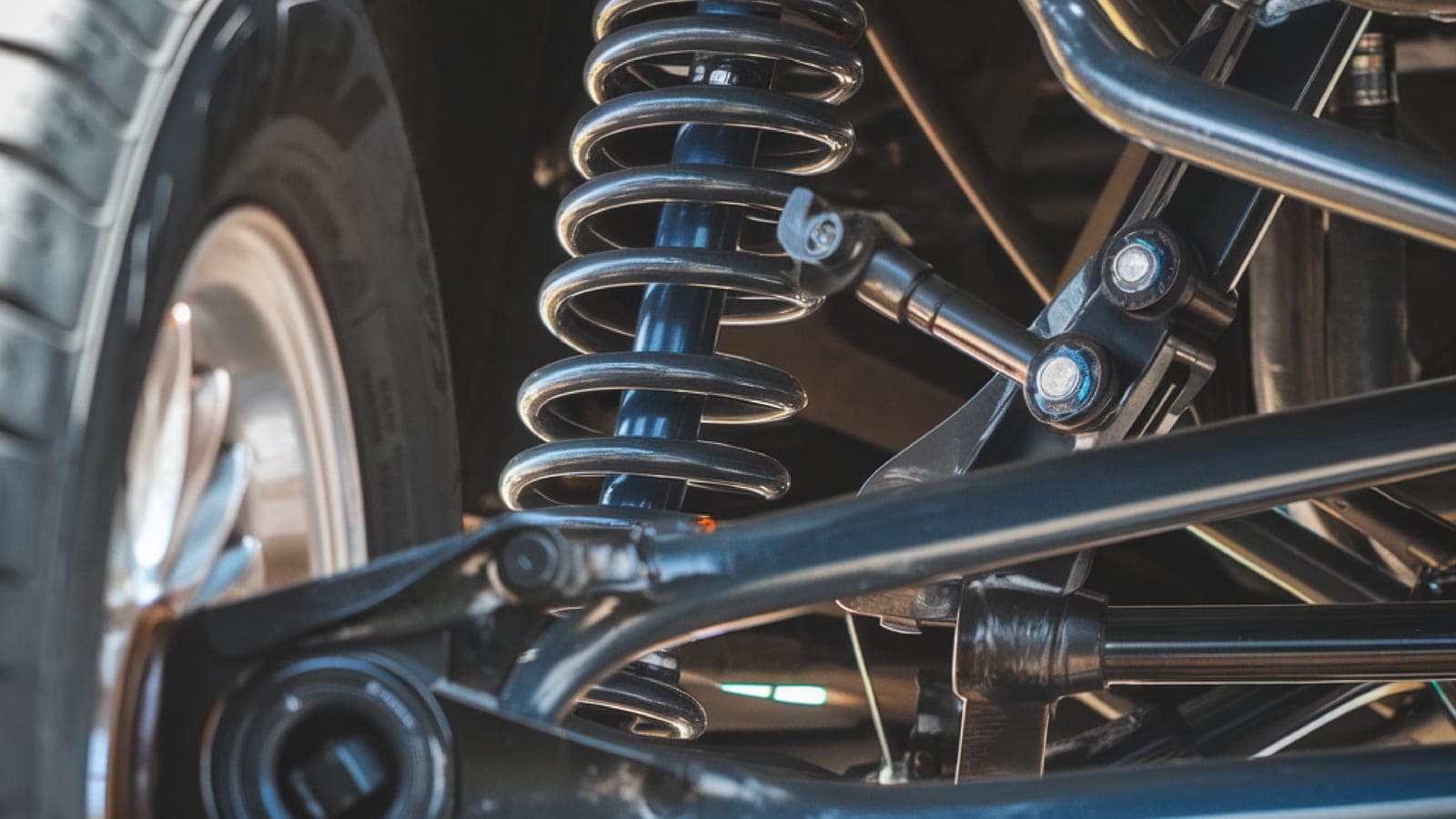 Close-up of a vehicle's strut, coil spring, and control arm