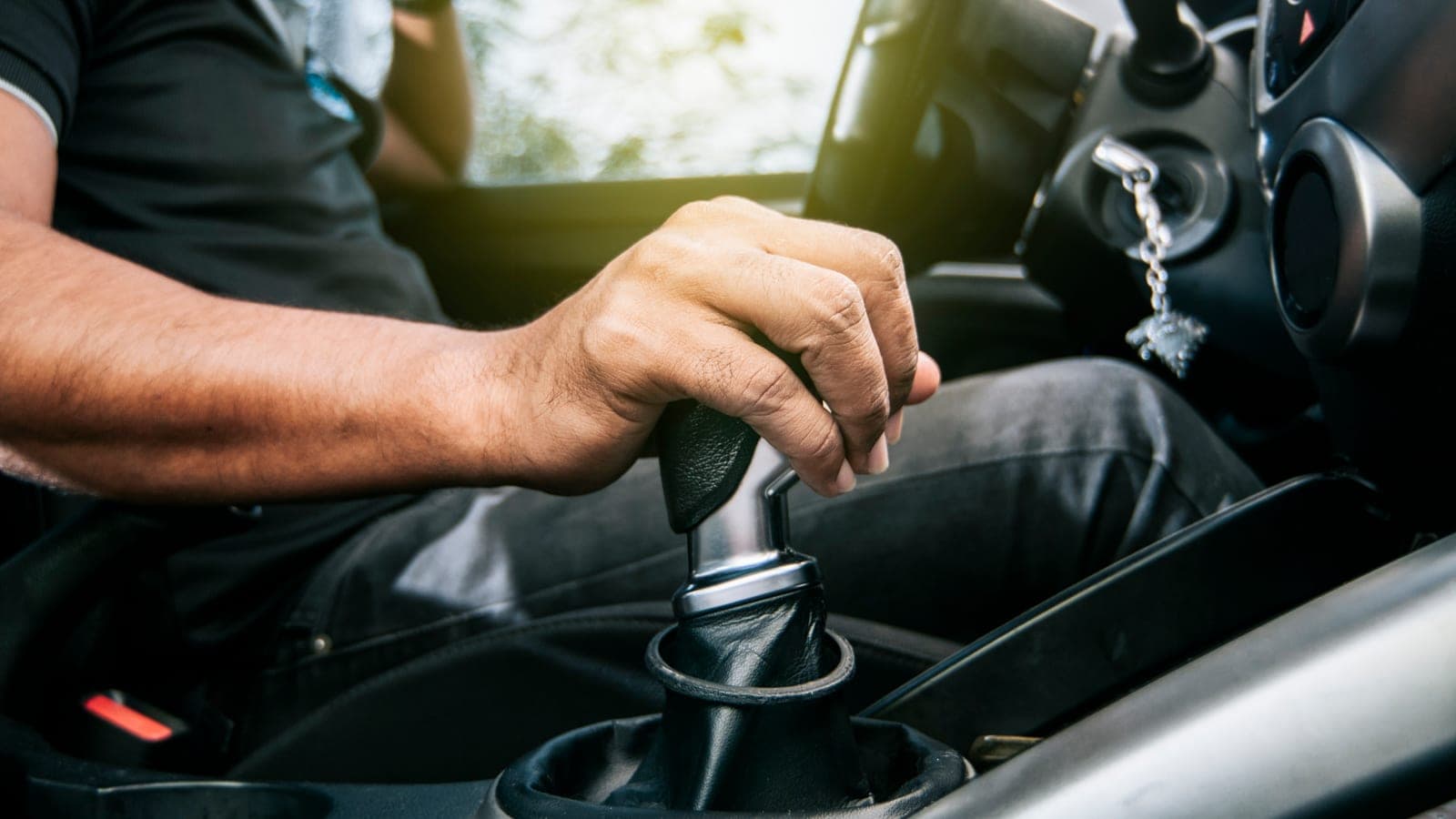 Driver shifting a manual transmission gear stick